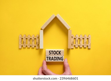 Stock trading symbol. Concept words Stock trading on beautiful wooden blocks. Beautiful yellow table yellow background. Businessman hand. House model. Business stock trading concept. Copy space. - Powered by Shutterstock