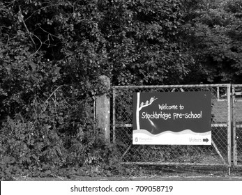 Stockbridge, Hampshire England - June 19, 2017: Monochrome Welcome To Stockbridge Pre School Banner Mounted On Gate To Playing Field