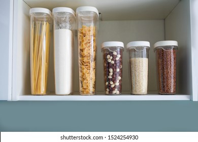 Stocked Kitchen Pantry With Food - Pasta, Buckwheat, Rice And Sugar . The Organization And Storage In Kitchen Of A Case With Grain In Plastic Containers.