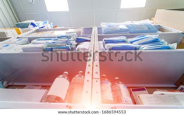 Stocked shelves\
of medical scrubs in storeroom. No people. Scrubs, medical masks,\
antiseptic, health care and prevention methods. Sanitizer. COVID-19\
and coronavirus identification.\
