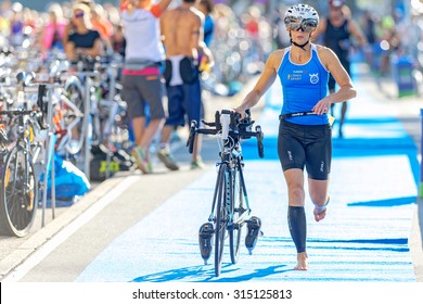 STOCKHOLM - AUG 23, 2015: Female Triathlete Running With Bike In The Transition Area The ITU World Triathlon Event In Stockholm.