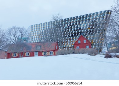 STOCKHOLM - JAN 15, 2017: The Spectacular Conference Building Aula Medica At University Hospital Karolinska Institutet. Red Cottages And Snow In The Foreground. January 15, 2017 In Stockholm, Sweden