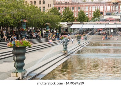 Stockholm, Sweden - 07 24 2019 - The Kings Garden Kungsträdgården With People Sitting Around The Fountain