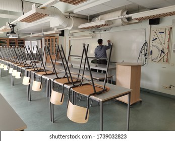 Stockholm, Sweden - 2020.05.17 - Totally Empty Classroom In A School Because Of The Corona Virus Epidemic. Teacher Alone In The Classroom Writing On The Whiteboard 