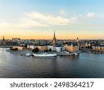 Stockholm, Sweden - 29 July 2024: Aerial view of Gamla Stan, old town in Stockholm in sunset with Riddarholmskyrkan church in foreground and a colorful clear sky background