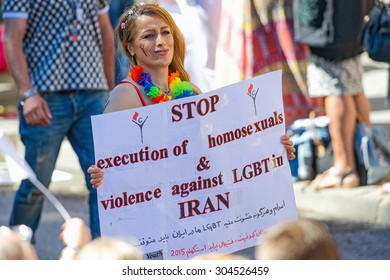 STOCKHOLM, SWEDEN - AUGUST 1, 2015: Woman with a protest banner of executions in Iran at the Pride parade in Stockholm. Approx 400.000 spectators at the streets.