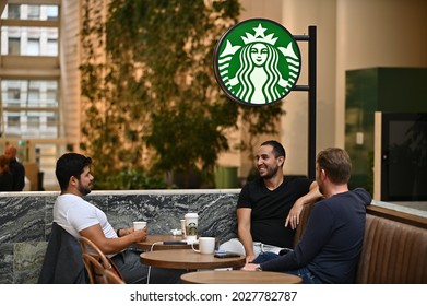 Stockholm, Sweden - August 19, 2021: Relaxed Patrons Sitting Around A Table At A Starbucks Café In Central Stockholm, Sweden.