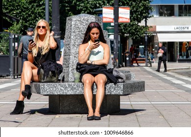 STOCKHOLM, SWEDEN - AUGUST 7, 2015: Two women with phone in hand at Norrmalmstorg in Stockholm city centre, Sweden 