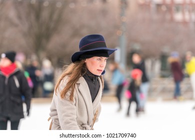 STOCKHOLM, SWEDEN - FEBRUARY 03, 2018: Side view portrait of woman wearing hat and coat skating at public ice skating rink outdoors in the city of Stockholm february 03, 2018. People in background. - Shutterstock ID 1021709740