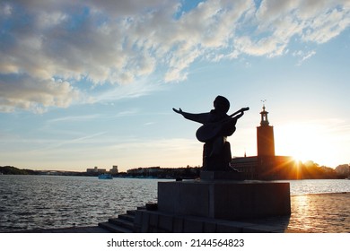 Stockholm, Sweden - June 26, 2019: Statue Of Evert Taube On Riddarholmen Island, View To Riddarfjärden, Södermalm And Stockholm City Hall