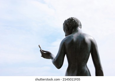 Stockholm, Sweden - June 26, 2019: Statue Of Woman Holding A Flower On The Stockholm City Hall Seafront With A View To Riddarfjärden