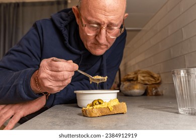 Stockholm, Sweden, A man eats dinner at a kitchen counter in an apartment by himself. - Powered by Shutterstock