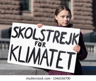 STOCKHOLM, SWEDEN - MARCH 22, 2019:  16-year-old Swedish climate activist Greta Thunberg demonstrating in Stockholm on Fridays. Holding a sign that says "School strike for Climate". 