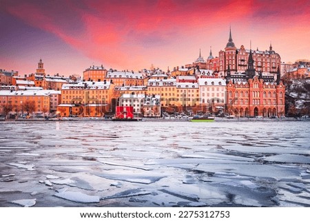 Stockholm, Sweden. Mariaberget and Sodermalm island in winter. Beautiful orange, violet and pink sky at sunset, reflected in frozen water of lake Malaren.