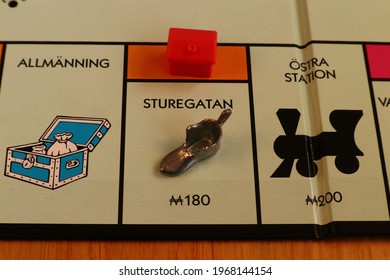 Stockholm, Sweden. May 02, 2021. Monopoly Board Game. Close Up Over The Orange Street Called Sturegatan. Written In Swedish. The Metal Shoe Token And A Red Hotel. Classical Boardgame.