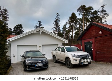 Stockholm, Sweden - May 12, 2019: Two Cars Parked In Driveway Near Small Typical Swedish Home.