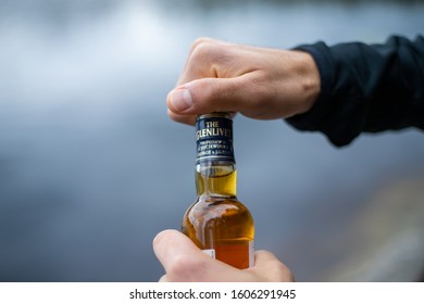 Stockholm / Sweden - May 12th 2018: The Glenlivet brand whisky bottle held and being opened by two hands