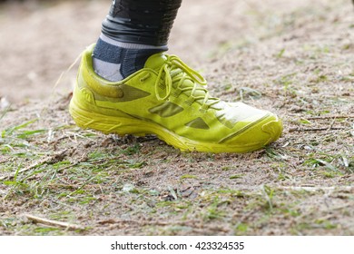 STOCKHOLM, SWEDEN - MAY 14, 2016: Closeup of yellow, wet shoes running in the obstacle race Tough Viking Event in Sweden, April 14, 2016