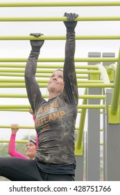 STOCKHOLM, SWEDEN - MAY 14, 2016: Concentrated Woman  Hanging In The Monkey Walk Bars Obstacle In The Obstacle Race Tough Viking Event In Sweden, April 14, 2016