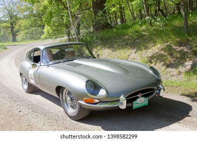 STOCKHOLM, SWEDEN - MAY 20, 2018: Silver color Jaguar E-type Serie 1 coupe classic car from 1963 driving in the public race Gardesloppet in the forests at Djurgarden, Stockholm, Sweden. May 20, 2018