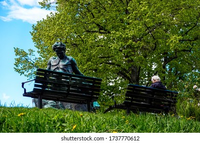 Stockholm, Sweden May 21, 2020 A Man Sits On A Bench In The Tegnerlunden Park Next To The August Strindberg Statue By Carl Eldh.