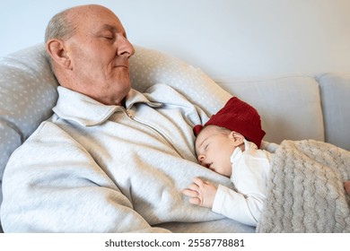 Stockholm, Sweden A  middle aged man  sleeps on the couch with his newborn granddaughter. - Powered by Shutterstock