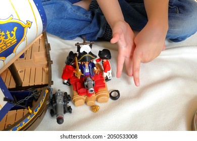 Stockholm, Sweden. September 04, 2021. Child Playing With Playmobil Pirates And British Red Coat Soldiers. No Face, Only Hands Visible. White Background.  