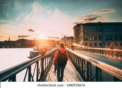 Stockholm, Sweden. Young Caucasian Woman Lady Tourist Traveler Walking On Famous Skeppsholmsbron - Skeppsholm Bridge. Popular Place, Landmark  And Destination In Stockholm, Sweden.
