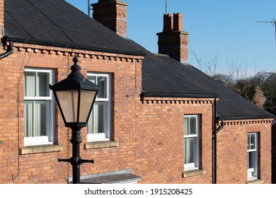 Stockport, Greater Manchester, UK. February 11, 2021 Crowther street steep terraced houses with gas lamp. Bright winter sun