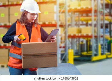 Stocktaking in the warehouse. A girl with a code reader and a tablet in the warehouse. Checking the availability of products. Recalculation of packages of product. Warehouse accounting control.