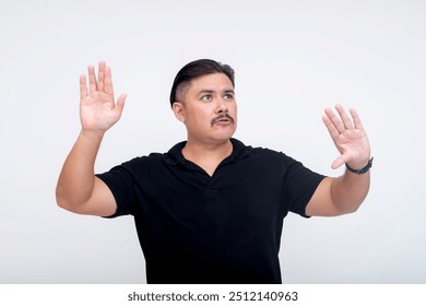 A stocky middle-aged man of mixed race interacting with a virtual screen or menu using his hands. For further editing purpose. Set against a white background. - Powered by Shutterstock