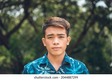 A Stoic And Pensive Filipino Man In A Blue Hawaiian Shirt.