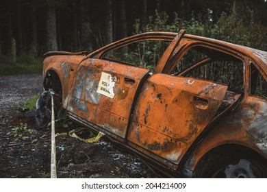 Stolen Car Burned Out And Abandoned Marked As A Crime Scene With Police Tape