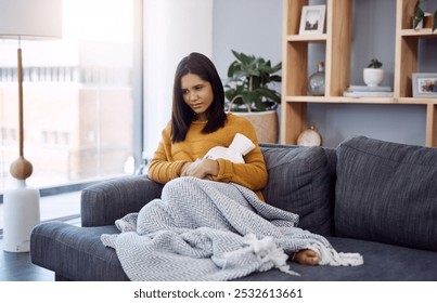 Stomach pain, sickness and woman on sofa with hot water bottle, menstrual cramps and home living room. Comfort, sore abdomen and girl with tummy ache from period, virus or constipation in house - Powered by Shutterstock