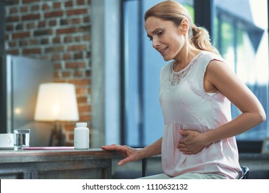 Stomach Pain. Worried Mature Woman Touching Belly And Looking Down