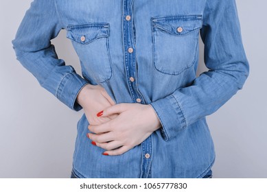 Stomach-ache concept. Cropped close up photo of sad upset depressed person people lady gripping right side with hands feeling acute pain isolated on gray background