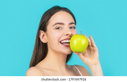 Stomatology Concept. Woman With Perfect Smile Holding Apple, Blue Background. Woman Eat Green Apple. Portrait Of Young Beautiful Happy Smiling Woman With Green Apples. Healthy Diet Food.