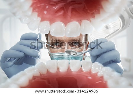 Stomatology. Dentist over open patient's mouth looking in teeth. Inside vew
