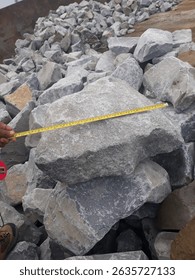 Stone aggregate measurement at the quarry using tape before loading to the barge or scow