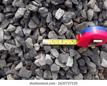 Stone aggregate measurement at the quarry using tape before loading to the barge or scow