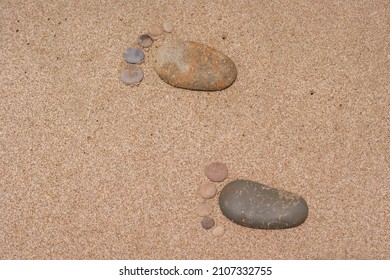 Stone Baby Footprints In The Sand Of A Beach