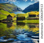 Stone barns with turf-top roof reflected in the calm waters of small pond in Saksun village, Faroe Islands. Colofful morning scene of Streymoy island, Denmark, Europe. Traveling concept background.
