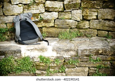 A stone bench on a trail with a backpack / Stone bench on the trail             