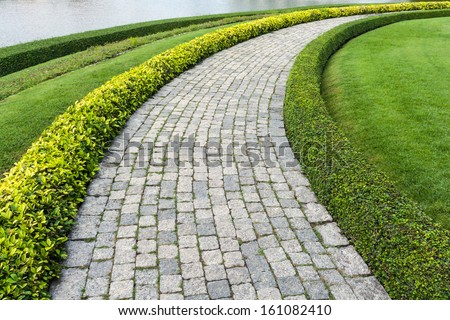 The Stone block walk path in the park with green grass background
