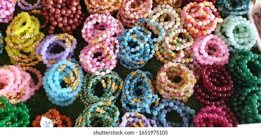 Stone Bracelet Colourful Amulets In Wat Tham Sua Temple, Kanjanaburi Thailand, Lucky Charm.Close Up Background Of Amulet Bracelet Or Necklace In Thailand Market.