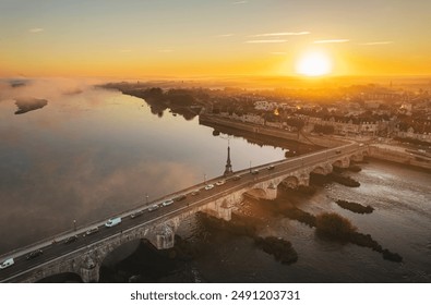 A stone bridge arches over a river, connecting a city on one side to a misty, sun-drenched landscape on the other - Powered by Shutterstock