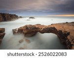 Stone bridge carved by the tides. Coastal landscape near Lisbon. stormy day at sunset.
Long exposure image rocky coastline os Cascais.