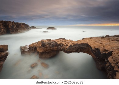 Stone bridge carved by the tides. Coastal landscape near Lisbon. stormy day at sunset.
Long exposure image rocky coastline os Cascais. - Powered by Shutterstock