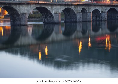 Stone Bridge on Lago di Como at sunset. Water and mountains. Lombardy, Italy, Europe.