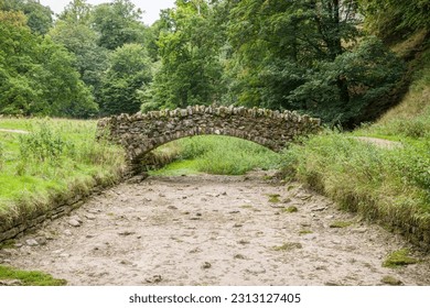 Stone bridge over a dried up riverbed. Drought in Seven Bridges Valley, North Yorkshire, England, UK